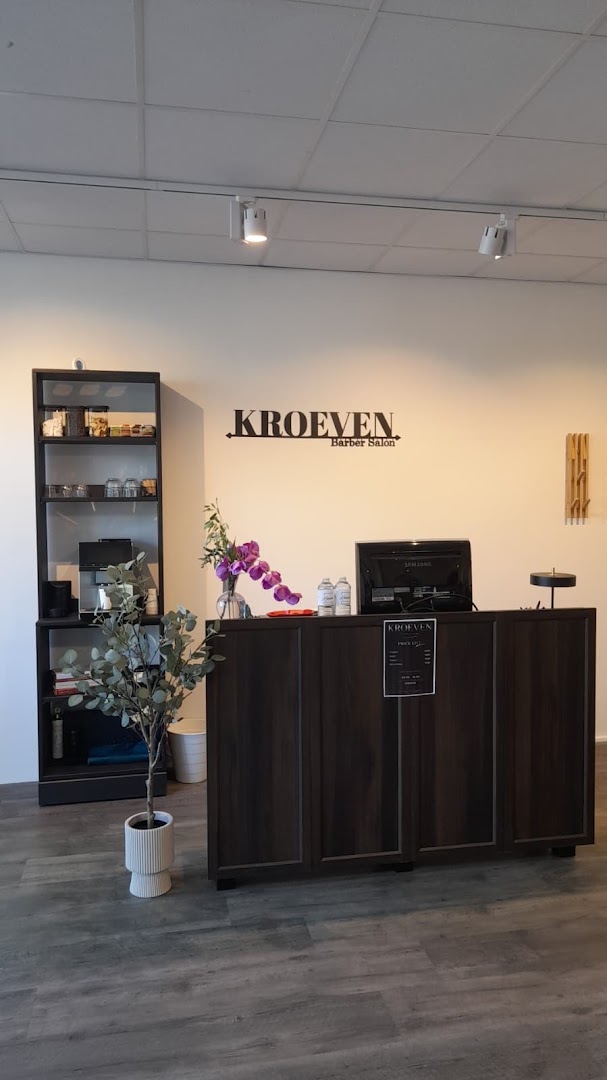 Receptie van Kroeven Barber met het wandlogo en de prijslijst